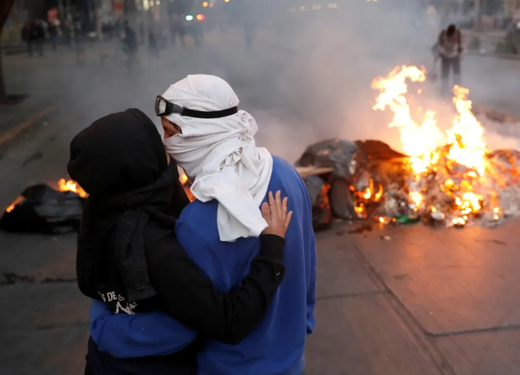 Maskovaní demonstranti v Chile protestovali proti ekonomickému systému a vládě. Fotografie z 25. listopadu 2019