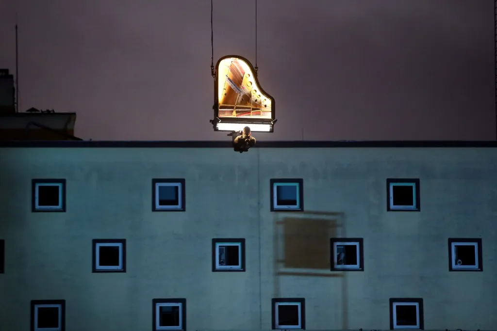 Netradiční koncert švýcarského umělce Alaina Rocheho zažili diváci na staveništi v německém Mnichově. Roche zahrál na klavír zavěšený na jeřábu