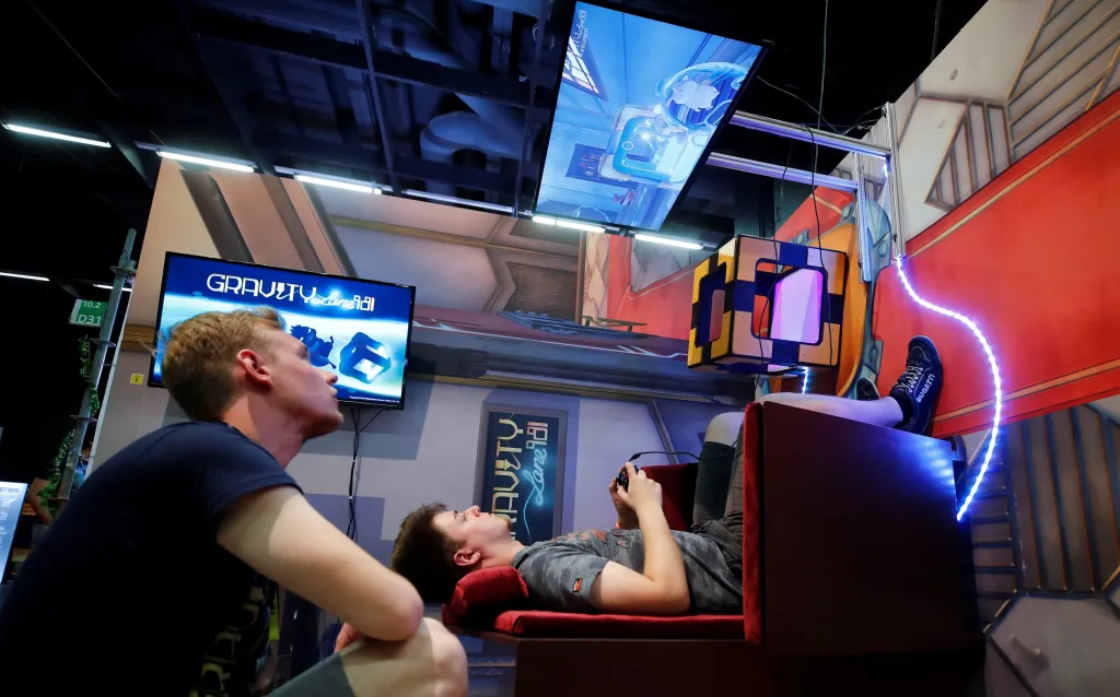 Gamescom 2019 ukazuje nejnovější trendy v digitálních hrách – například hru Gravity, kterou hráč hraje usazen na židli zavěšené na zdi