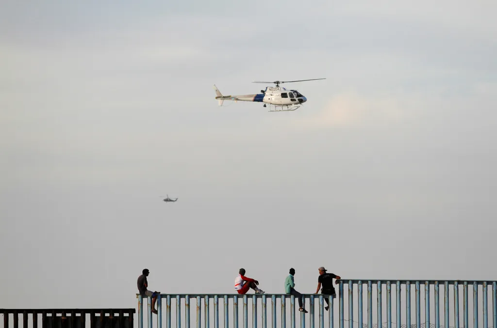 První migranti z tzv. karavany migrantů dorazili k hranicím USA. Někteří z nich se snaží přelézt plot mezi USA a Mexikem nedaleko mexického města Tijuana