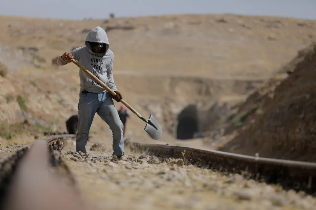 Dělník pracuje na trati poblíž železničního tunelu v Mosulu v Iráku