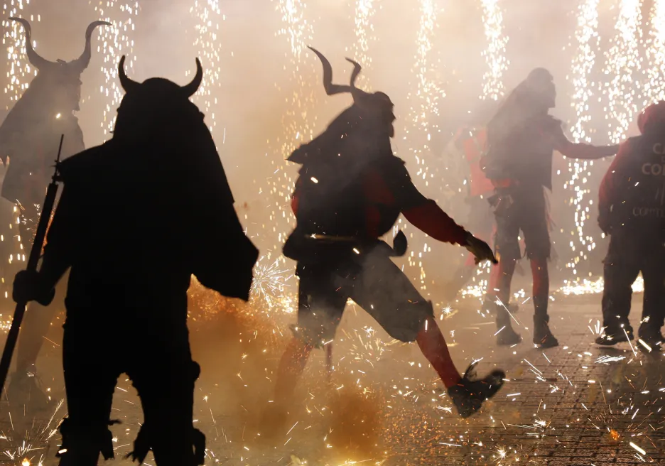 Muži oblečení jako démoni v ulicích Mallorky během tradičního festivalu Katalánska a Baleárských ostrovů s názvem Correfoc, při němž se lidé v kostýmech ďáblů a ohnivých zvířat mísí s publikem a tančí na hudbu