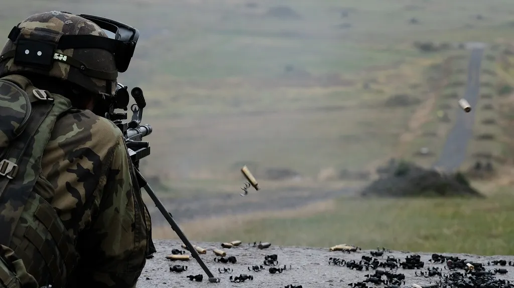 Střelba z lehkého kulometu FN Minimi. Na pravé straně fotky jsou vidět odlétávající nábojnice a článek pásu