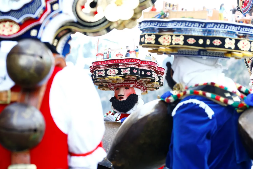 Muži oblečení v kostýmu postaviček "Chlaeuse"putují vesnicí Urnaesch ve Švýcarsku