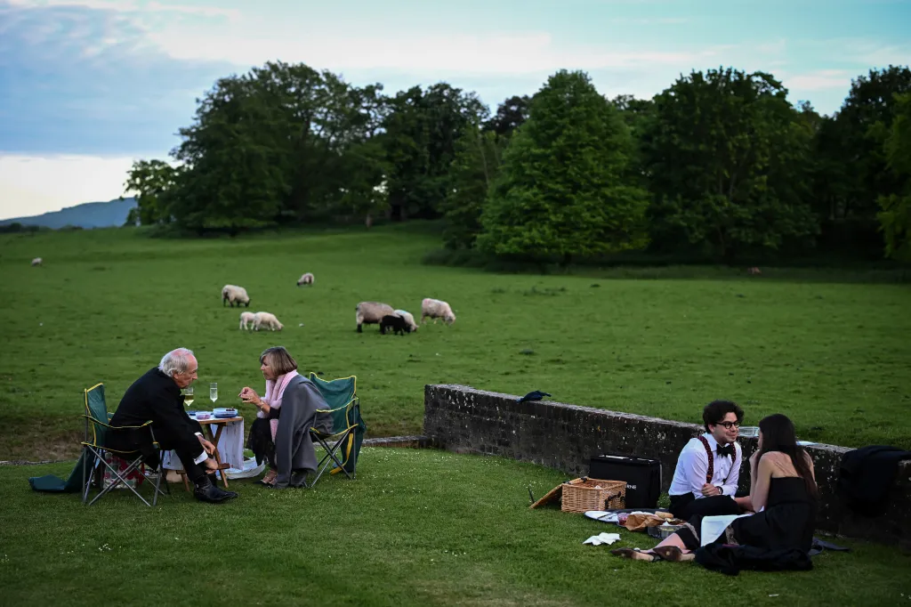 Operní fanoušci si užívají piknik s výhledem na pasoucí se ovce