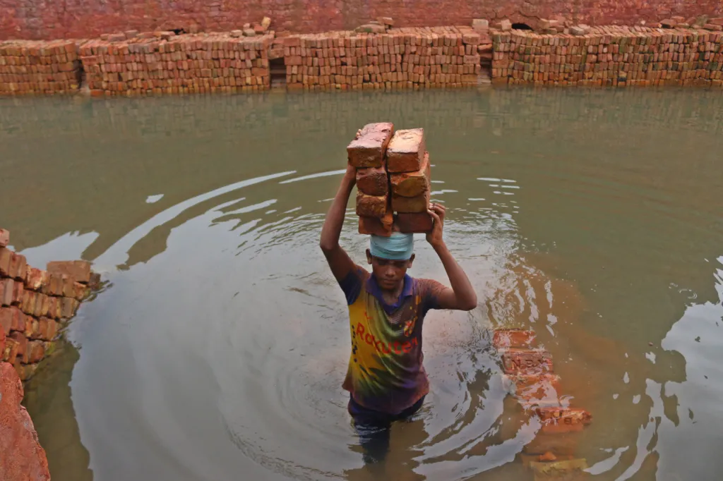 Cihláři z bangladéšského Savaru zachraňují během záplav nevypálené cihly, které by se ve vodě rychle rozpadly