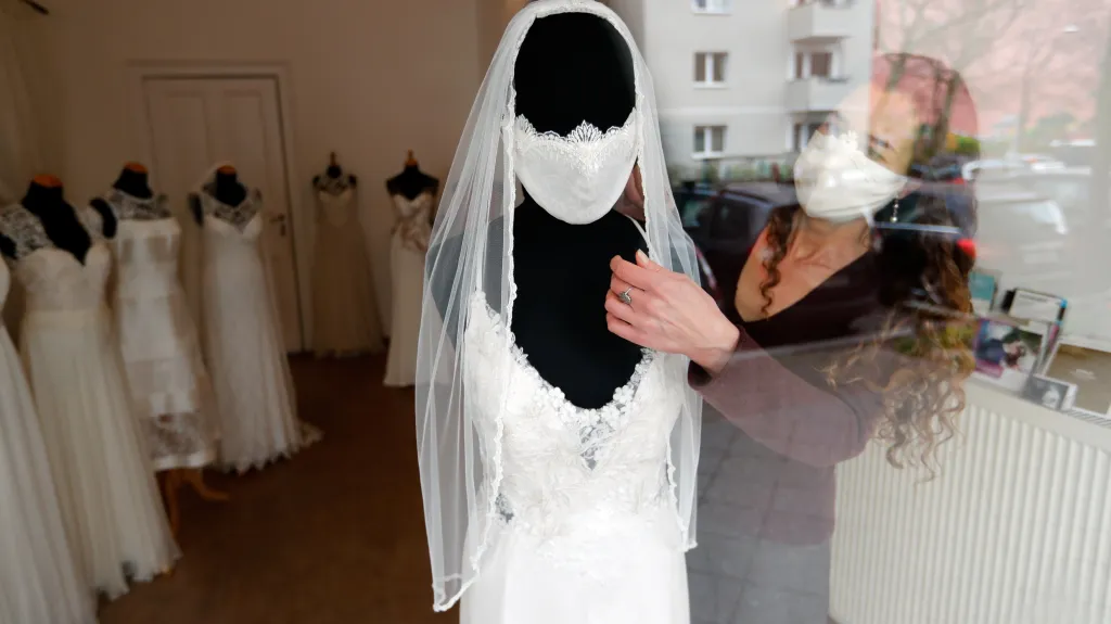 Model svatebních šatů s rouškou v době koronaviru