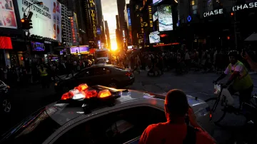 Lidé pozorují zapadající Slunce nad Manhattanem