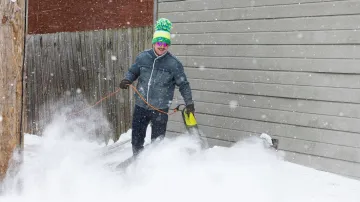 Obyvatel St. Louis odstraňuje sníh fukarem na listí, 24. ledna 2026