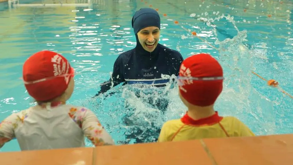 Muslimka učí děti plavat