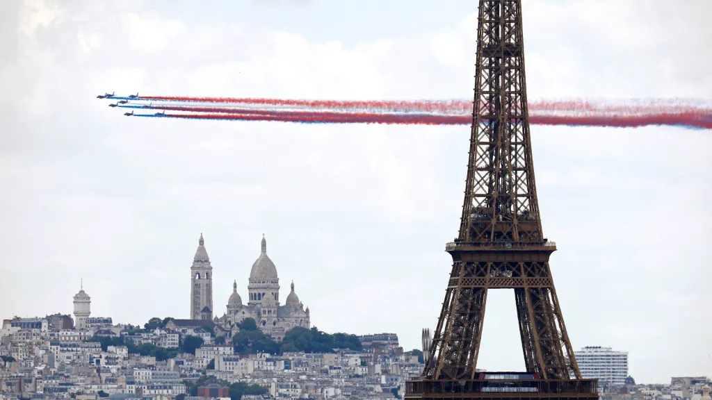 Akrobatická skupina Patrouille de France přelétá nad Paříží, v popředí je Eiffelova věž