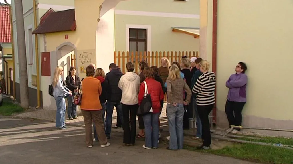 Propuštění zaměstnanci diskutují před firmou