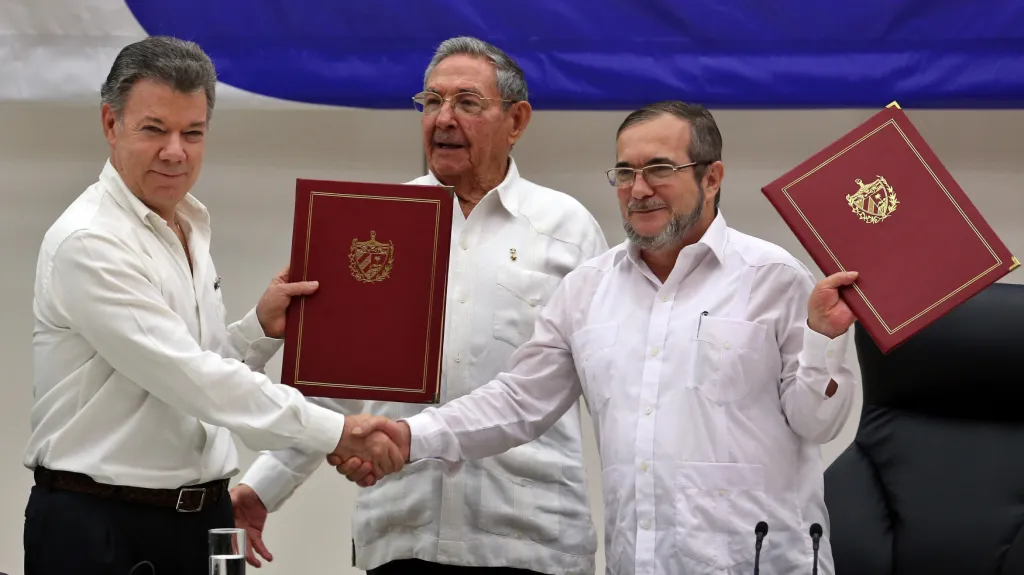 Mír podepsán. Kolumbijský prezident Juan Manuel Santos (vlevo) s velitelem povstalců Timoleónem Jiménezem (alias Timochenkem, vpravo). Přihlíží kubánský prezident Raúl Castro