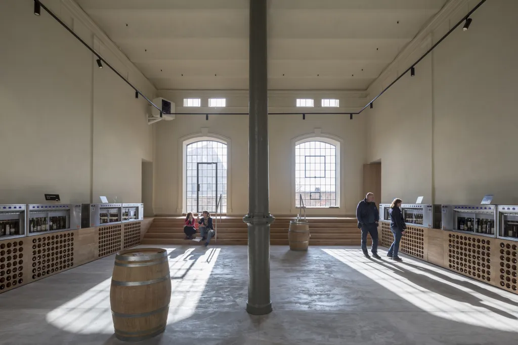 Dům vína vznikl přestavou pivovaru z devatenáctého století, architekti z něj ale zachovali jen vnější strukturu a v ní vytvořili zcela nový vnitřní prostor