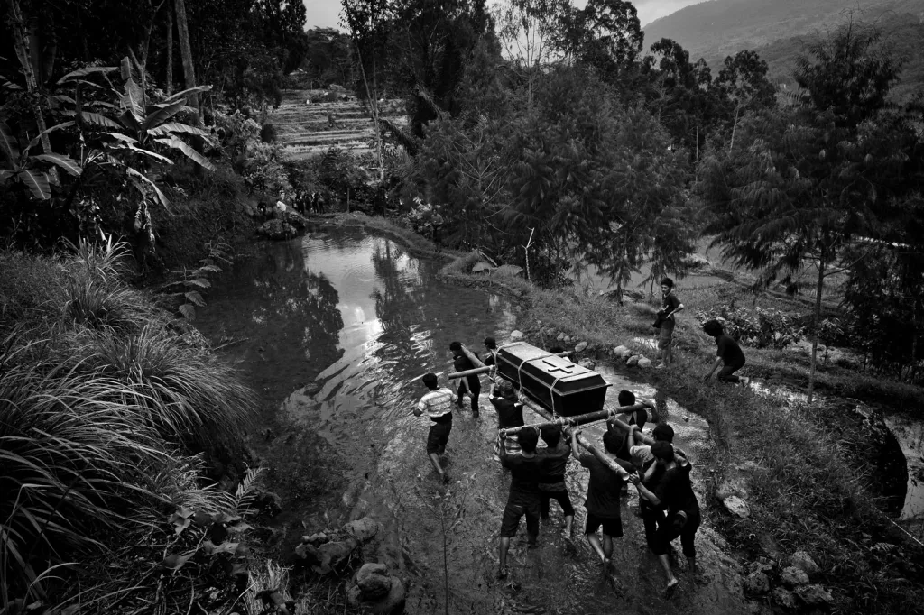 Vítěz cestovatelské fotografie roku 2017 Belgičan Alain Schroeder fotografoval pohřební rituály v Indonésii. Na snímku je pohřební průvod ve vesnici Sereale na ostrově Sulawesi. Lidé nesoucí rakev kolem svých obydlí zpívají a křičí, aby odehnali všechny zlé duchy.