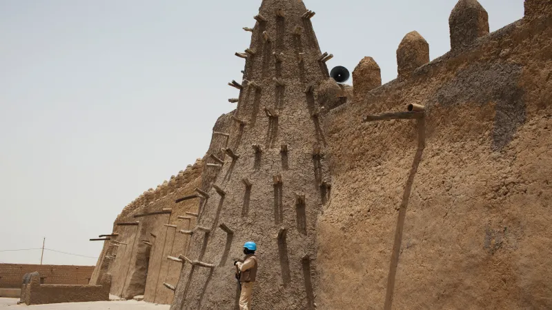 Příslušník mírových sborů OSN před mešitou v Timbuktu