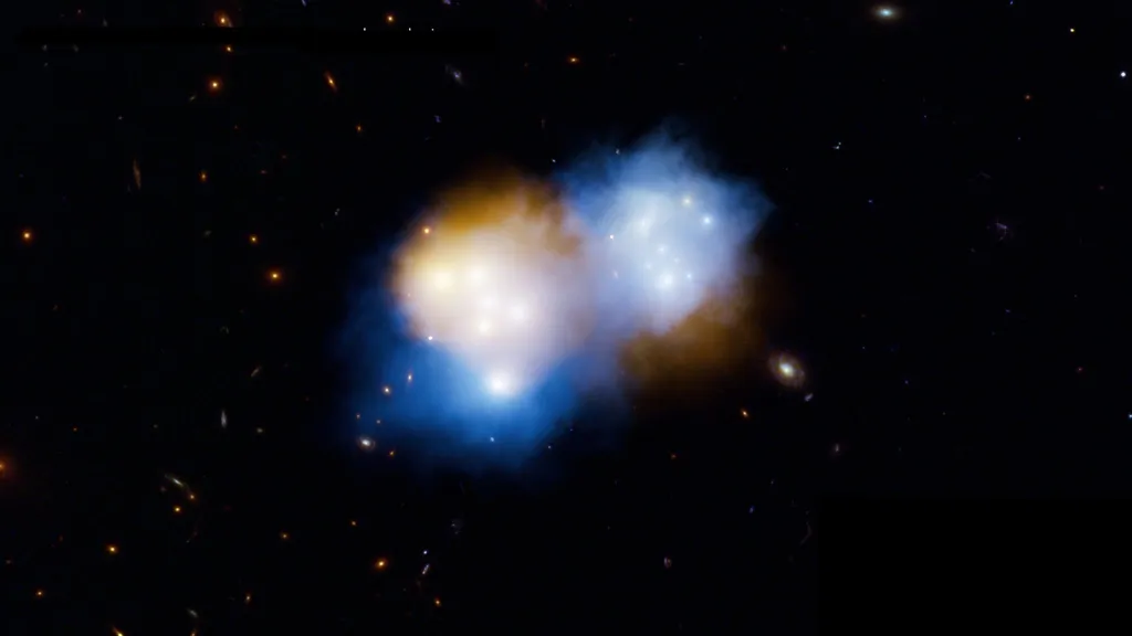 Srážka dvou kup galaxií: oranžově je zobrazená klasická hmota, modře temná hmota