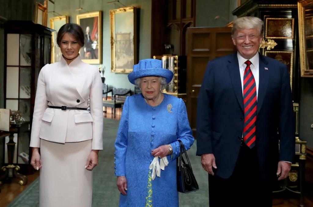 Prezident Donald Trump již Británii navštívil 13. července 2018. Na snímku je se svou manželkou Melanií a britskou královnou v Grand Corridor během jejich návštěvy Windsorského hradu