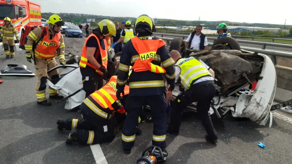 Hasiči vyprošťují zraněnou osobu z auta