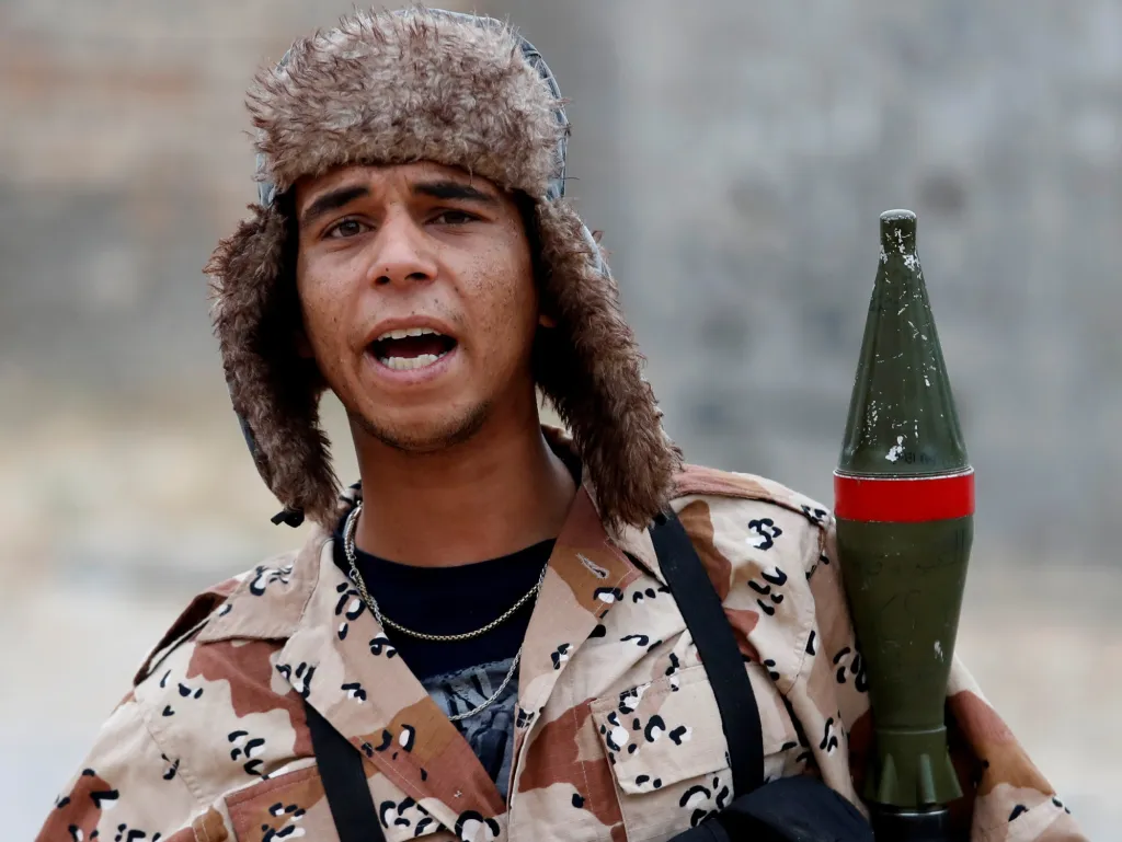 Pokračující konflikt v Libyi si vyžádal další oběti. Jeden z vojáků vykřikuje na okraji Tripolisu během palby jméno vůdce Libyjské národní armády Chalífa Haftara