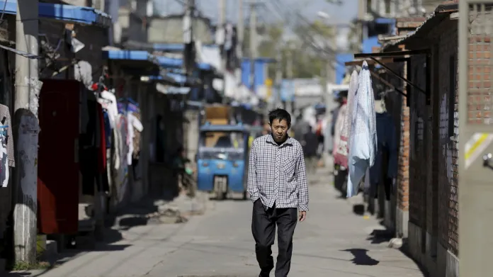 Muž procházející uličkou v zóně obývané pracovníky z řad přistěhovalců na okraji Pekingu