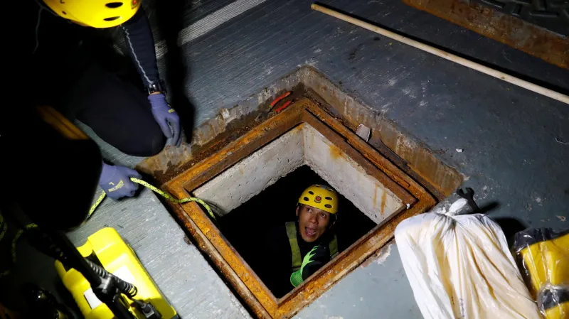 Záchranář kontroluje hongkongskou kanalizaci, zda se v ní neztratili někteří z protestujících studentů