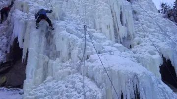 Horolezec na ledové stěně ve Víru