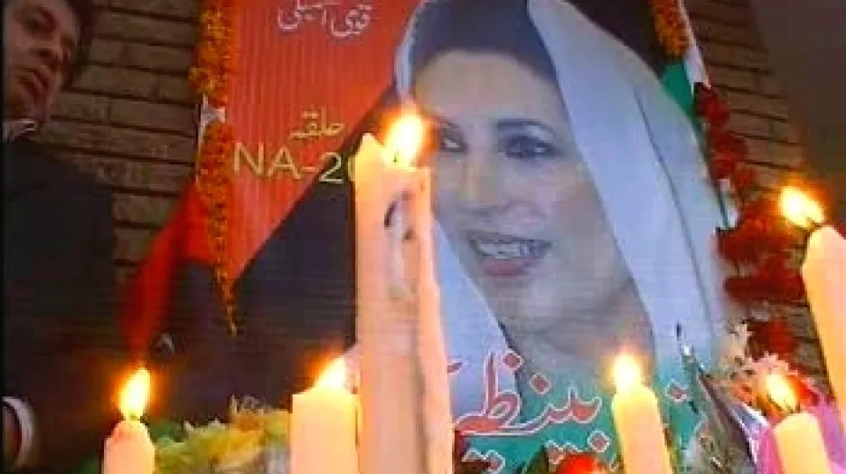 Pákistánci zapalují svíčky u obrazu Bénazír Bhuttové