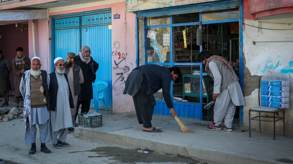 Lidé odstraňují rozbité sklo ze svého obchodu po pákistánském leteckém útoku v lokalitě Darul Aman v Kábulu v Afghánistánu, 27. února 2026