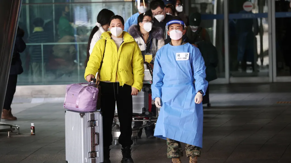 Jihokorejský voják odvádí skupinu čínských turistů z letiště