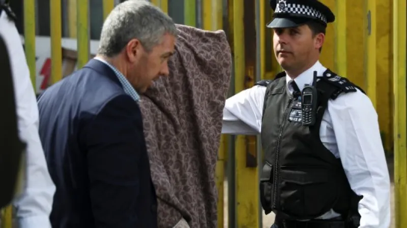 Policie odvádí zadrženého při zásahu v Newhamu