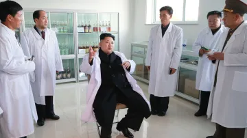 Sedící Kim Čong-un kouká na stojící spoluobčany