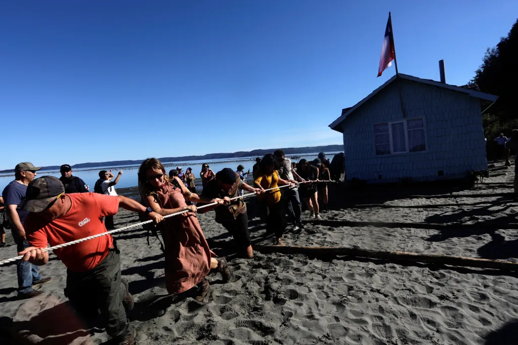 Místní obyvatelé spolu s turisty táhnou dům na nové místo na ostrově Lemuy v Chile