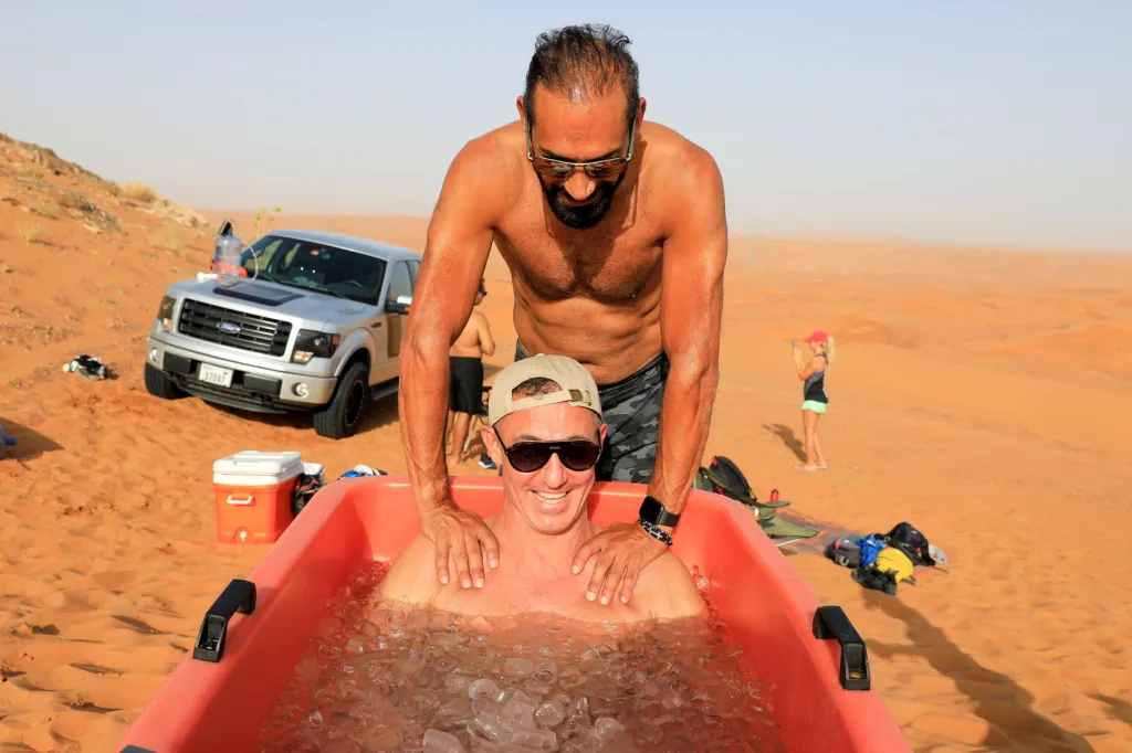 Jeden z účastníků lázeňské „ledové“ terapie sedí ve vaně s ledem v poušti poblíž města Šardžá ve Spojených arabských emirátech, kde teploty dosahují ke čtyřiceti stupňům Celsia