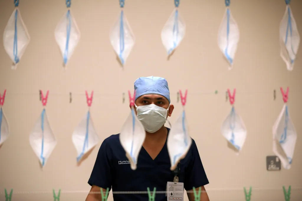 Zdravotní technik kontroluje obličejové masky N95, které mají být sterilizovány ultrafialovým zářením, v nemocnici v Abú Dhabí