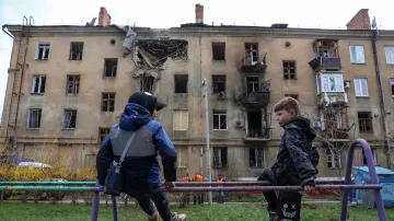 Děti si hrají poblíž bytového domu v Kramatorsku, který byl zasažen ruským útokem dronem