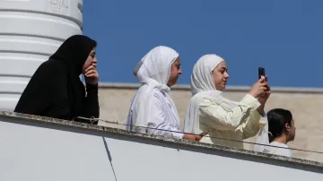 Palestinky pozorují ze střechy domu izraelské osadníky přicházející do vesnice Till