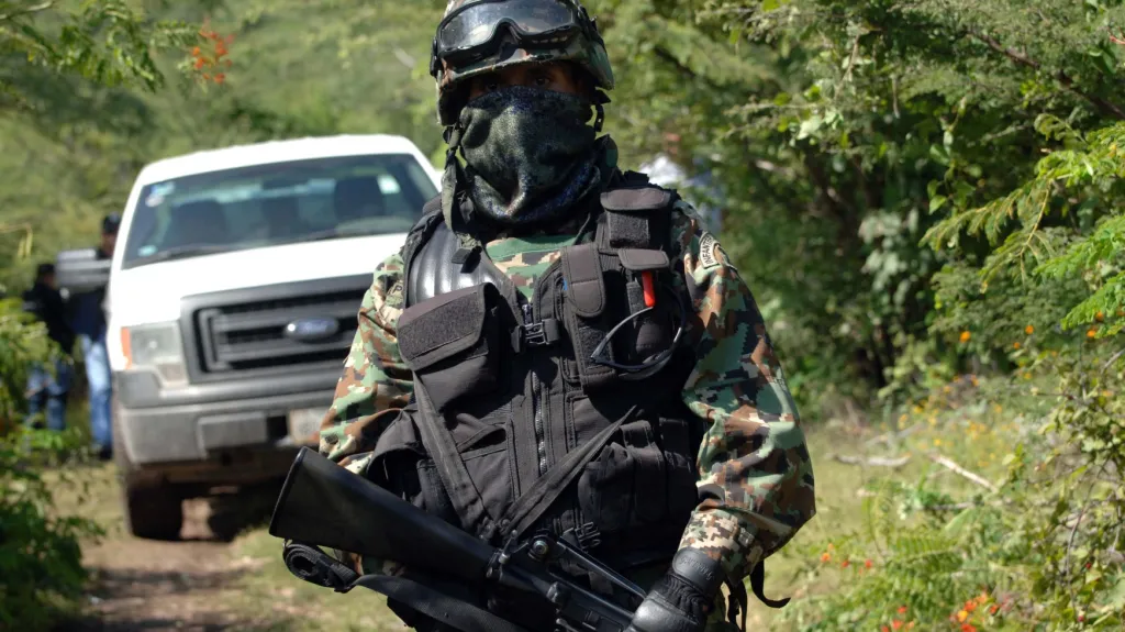 Mexický voják střeží masový hrob