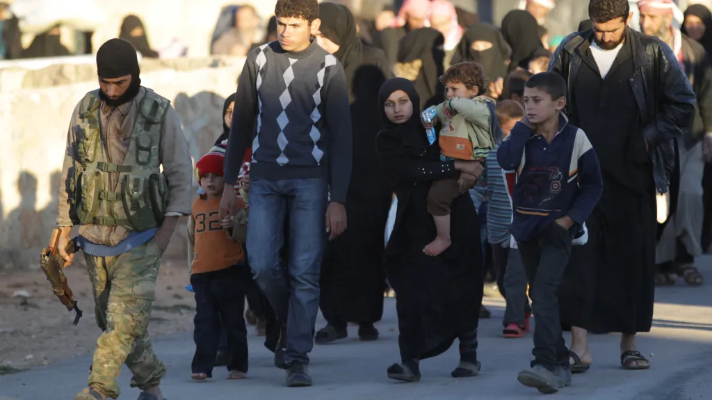 Jeden z rebelů odvádí lidi, kteří uprchli před IS