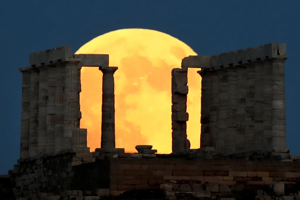 Měsíc v superúplňku před svým zatměním na pozadí chrámu boha Poseidona na mysu Sounion nedaleko Atén