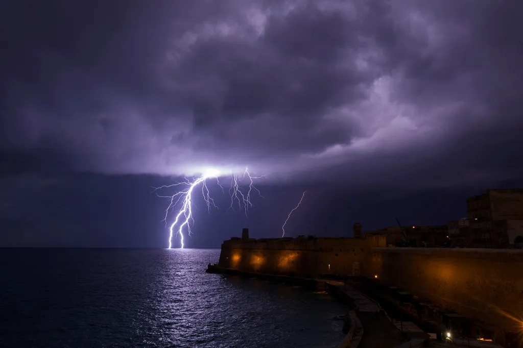 Blesk při úderu do vodní hladiny oceánu nedaleko pevnosti Fort St. Elmo při bouři u ostrova Malta
