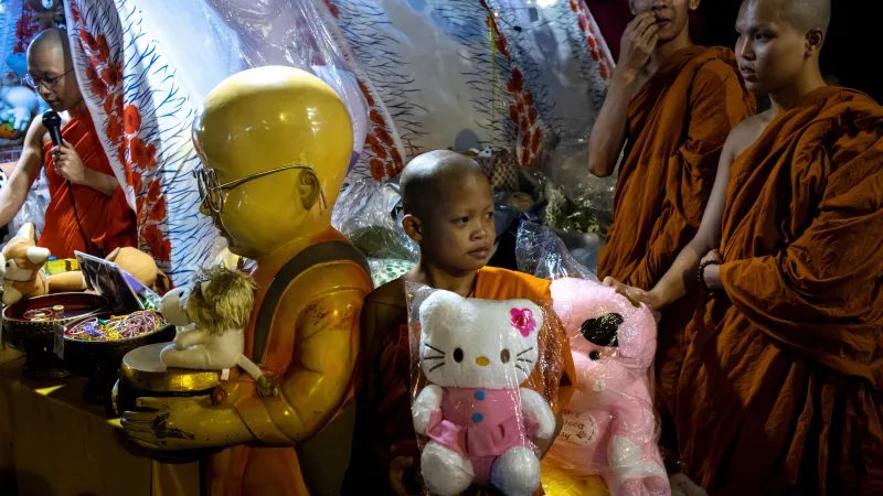 Buddhistický mnich drží hračku Hello Kitty během festivalu v chrámu v Bangkoku