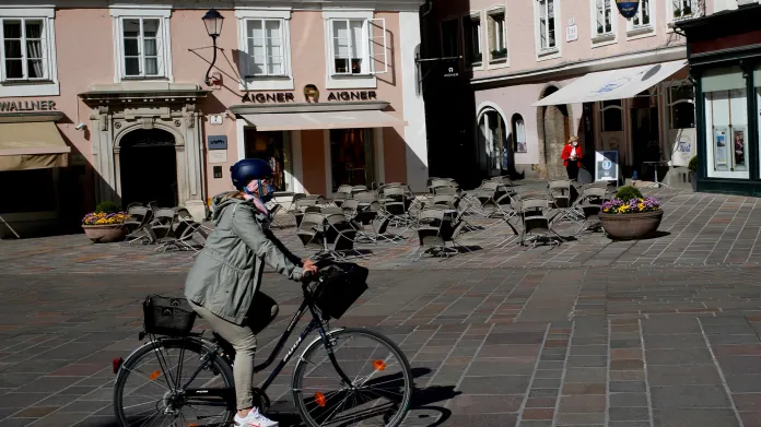 Žena na kole před uzavřenou kavárnou v rakouském Salzburgu