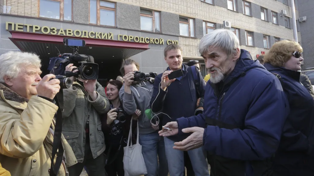 Jurij Dmitrijev mluví s lidmi před budovou soudu