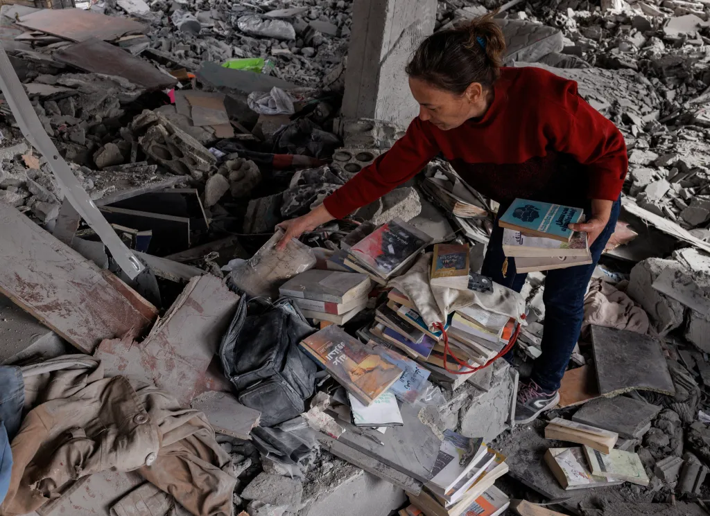 Katy Maroue sbírá knihy v troskách svého domu poté, co se během příměří vrátila, aby posbírala své věci