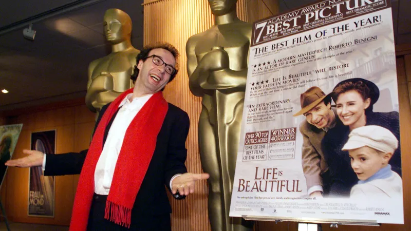 Roberto Benigni před plakátem na film Život je krásný, nominovaném na Oscara (1999)