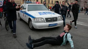 Demonstrant v Petrohradě blokuje policejní auto