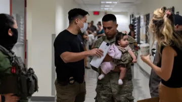 Agent ICE hovoří s vojákem, který drží dítě, jehož matka se účastní slyšení u amerického imigračního soudu na Manhattanu, ilustrační snímek