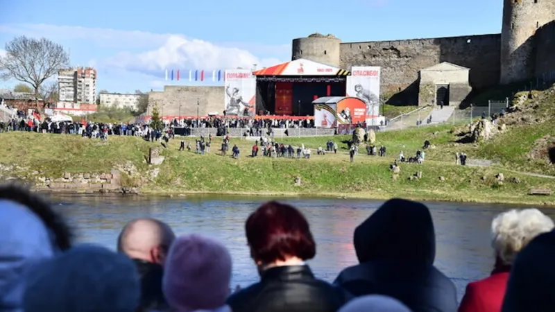Lidé na nábřeží Narvy sledují koncert ke Dni vítězství (9. května 2025)