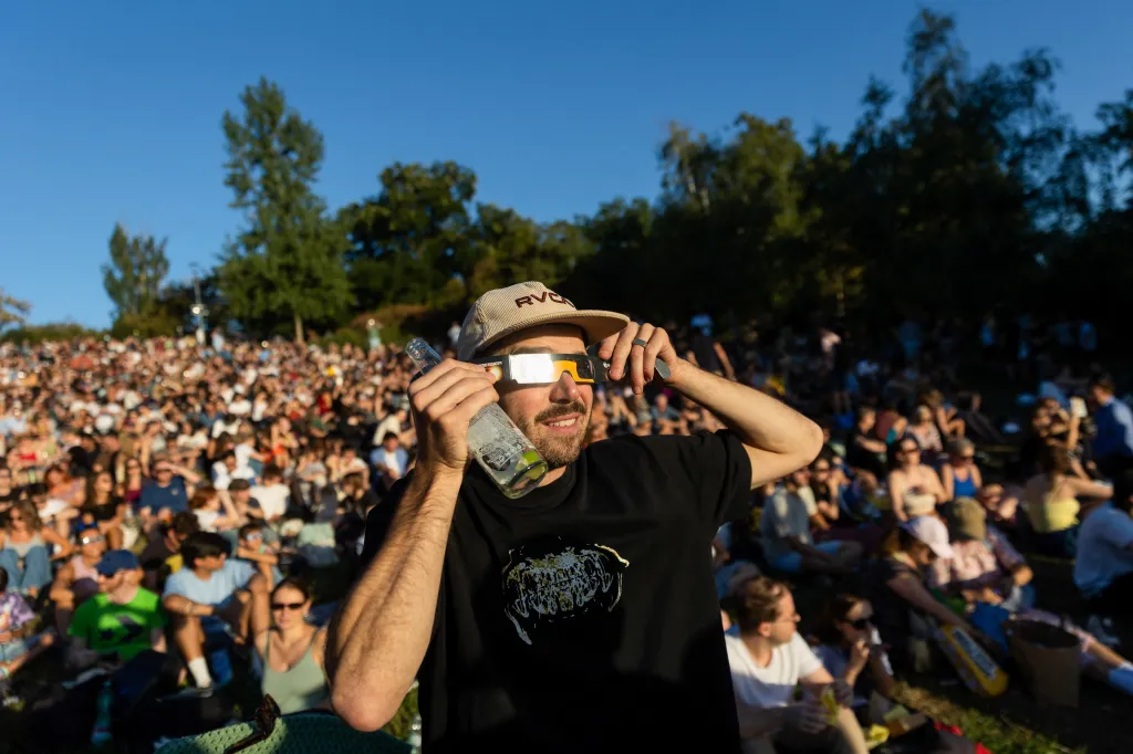 Lidé sledují zatmění Slunce v Praze